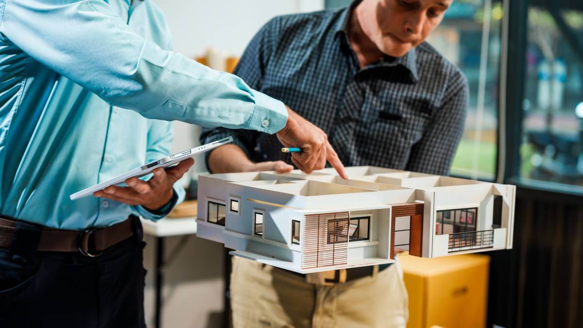 Two men looking at building model